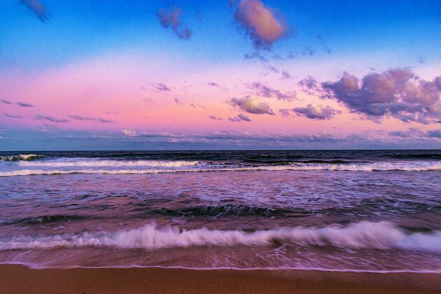 海洋美丽的拍摄日落在海滩上与多云的天空背景自然惊人风景
