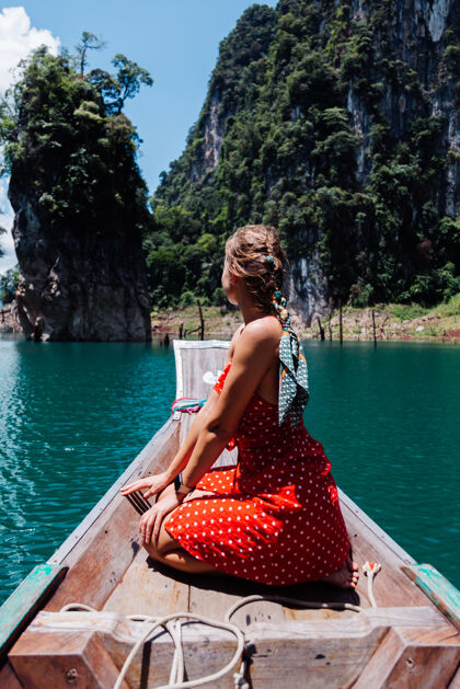 户外穿红色夏装的高加索女子在泰国亚裔船上度假 环游泰国湖泊探索欢乐
