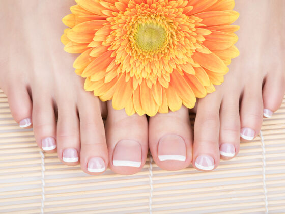 沙龙特写照片的一个女性脚与白色法国足疗指甲治疗水疗护理