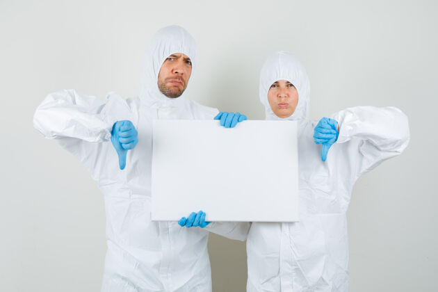 肖像两个医生穿着防护服 戴着手套拿着空白帆布医院站立保健