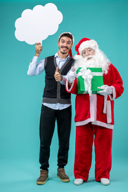 圣诞老人前视图圣诞老人和年轻的男性谁持有白云标志蓝色背景圣诞蓝色圣诞老人