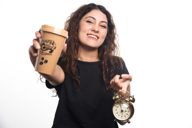 女士微笑的女人展示一杯咖啡 白色背景上有时钟高质量的照片年轻人手杯子