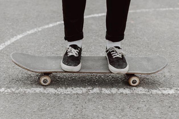 运动滑板女孩站在滑板上女人生活方式滑板