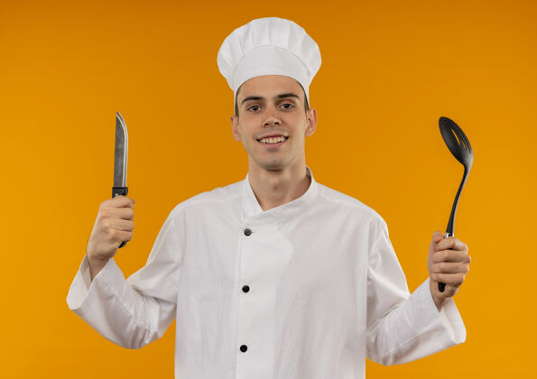 制服笑容可掬的男青年酷毙了 穿着厨师制服 手里拿着刀和勺子勺子男戴着