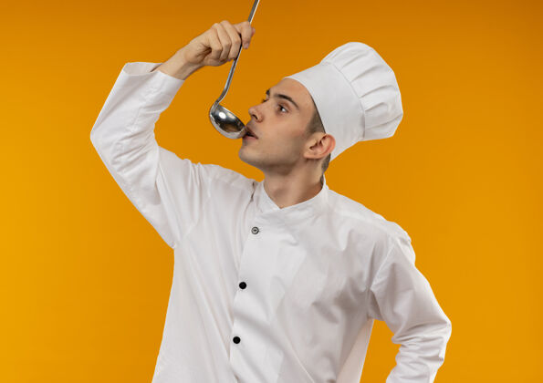 厨师站在侧视图年轻男性酷穿着厨师制服尝试汤从勺子酷男勺子