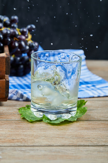 叶一杯白葡萄酒放在木桌上 上面放着葡萄高质量的照片饮料葡萄饮料