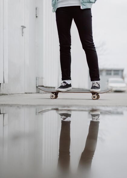 年轻滑板女孩站在滑板上运动滑板户外