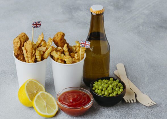 土豆高角度的鱼和薯条在纸杯与英国国旗和啤酒瓶国旗鱼伟大