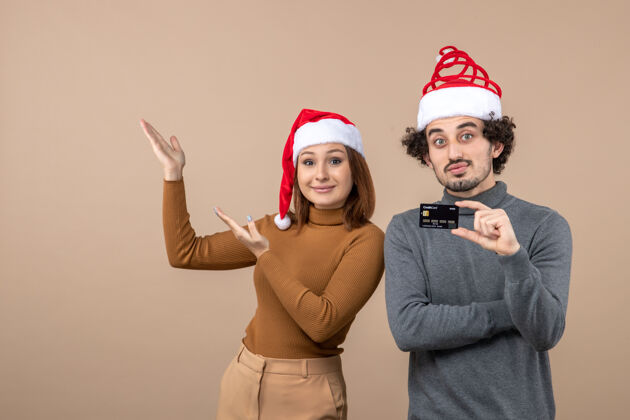心情圣诞节心情激动满意情绪冷淡情侣戴红色圣诞老人帽出示银行卡微笑帽子微笑
