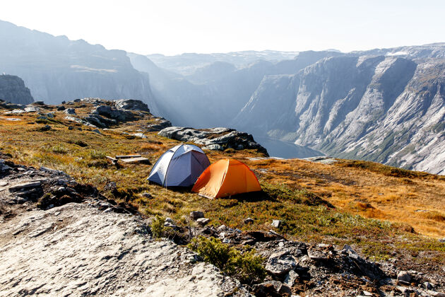 森林在挪威山上有两个帐篷日出平地湖泊