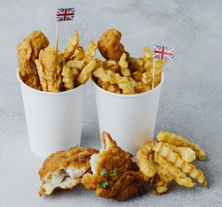食物高角度的鱼和薯条在纸杯与英国国旗传统烹饪菜