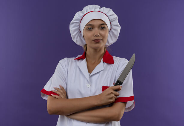手自信的年轻厨师女身穿厨师制服双手交叉持刀在隔离墙上刀年轻制服