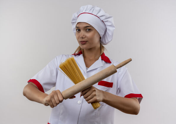 手年轻的女厨师穿着厨师制服 手拿意大利面和擀面杖 站在孤零零的白墙上交叉穿年轻