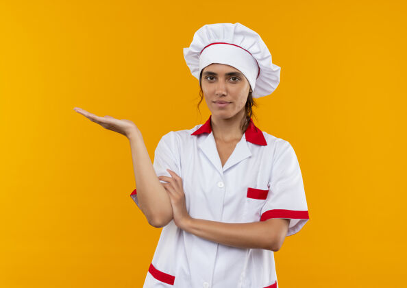 穿高兴的年轻女厨师穿着厨师制服点着手边有复印空间厨师高兴女