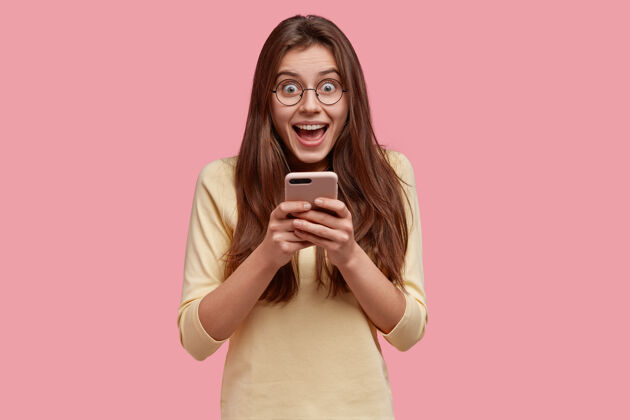 信息拍得挺满意的女人捧着手机 开心地在社交网络上交流短信满意设备眼镜