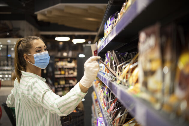 消毒在超市购物时保护自己免受电晕病毒侵害的女人室内开业人
