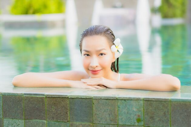 游泳肖像美丽的亚洲年轻女子放松微笑周围的室外游泳池在酒店度假村水放松度假村
