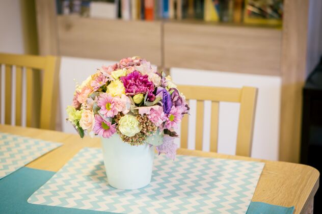 植物木桌上一个白色花瓶里一束五颜六色的花的特写镜头开花季节新鲜