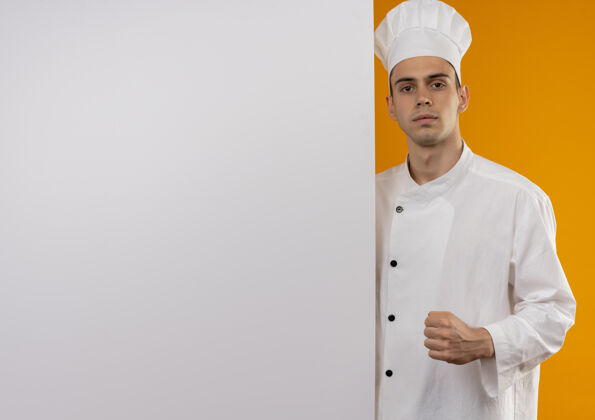 制服年轻男性身穿厨师制服 手持白色墙壁 在隔离的黄色墙壁上展示强烈的手势 并留有复制空间握强壮展示