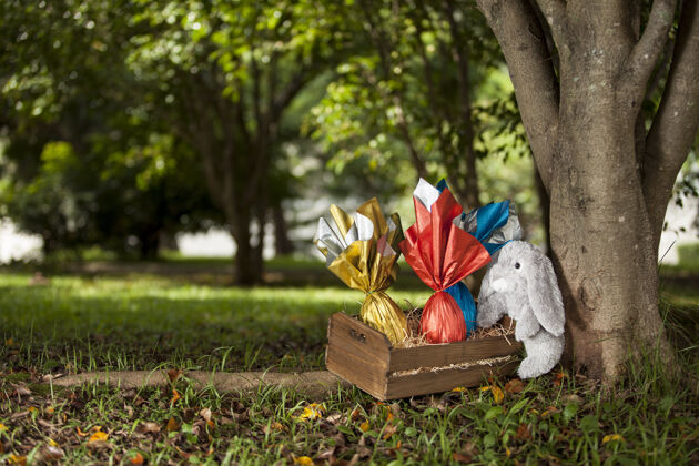 巴西一只毛绒兔子在树下抱着一篮子巴西东方人的蛋礼品装饰草