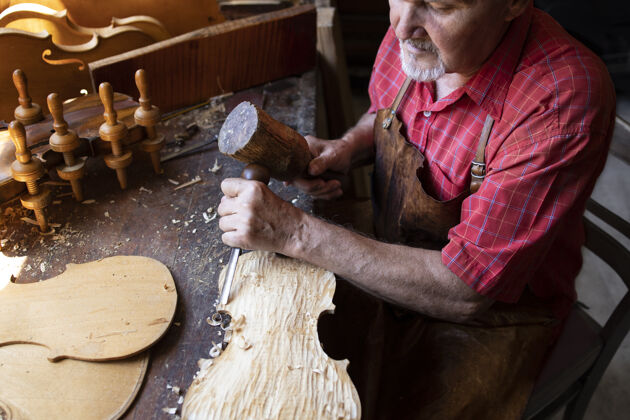 木匠一位经验丰富 头发花白的高级木匠在木工车间里做他的工作工艺工具