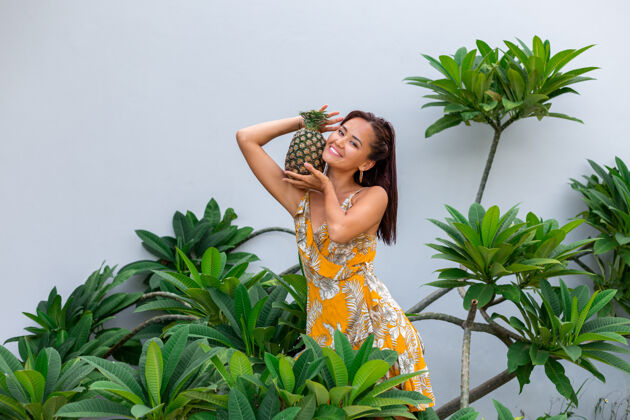 菠萝身着黄色夏装 手持菠萝的快乐亚洲微笑女人的画像饮食饮食素食
