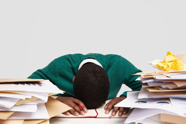 工作狂有压力的工作狂总是低着头坐在办公桌上 感到疲劳和过度工作 有很多工作要做 为即将到来的考试做准备 把信息写在日记里过度工作疲劳压力