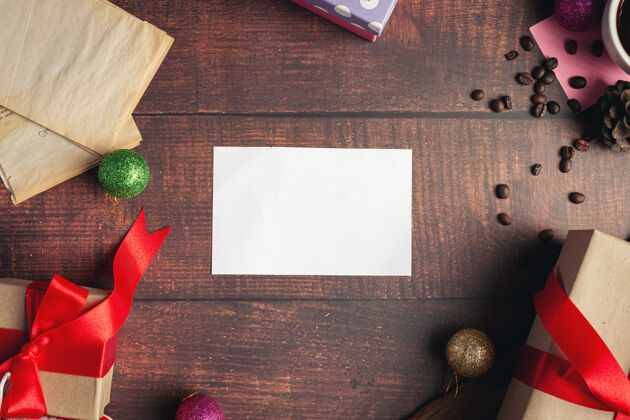 圣诞快乐一张白纸和一个礼品盒放在木地板上丝带包装现代