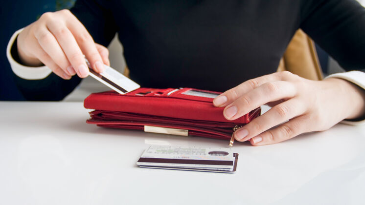支付特写镜头年轻女商人把信用卡放在她的钱包里银行移动在线