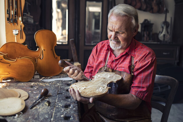 车间资深木匠在他的旧时尚工作室里雕刻木头制作人勤奋